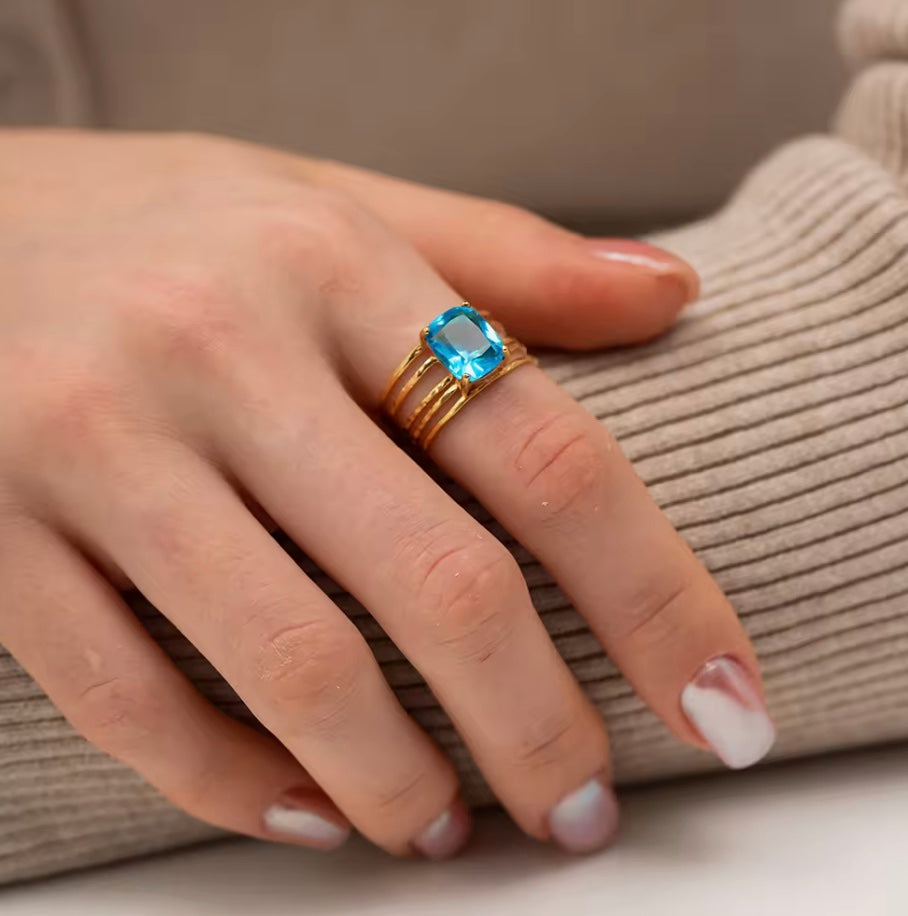 Vandfast, 18 k forgyldt åben ring i stål med azurblå zirkon